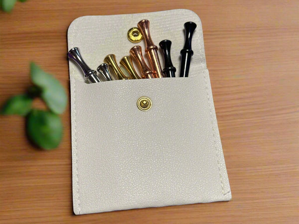 Small beige leather case with metal crib pegs  on a wooden surface