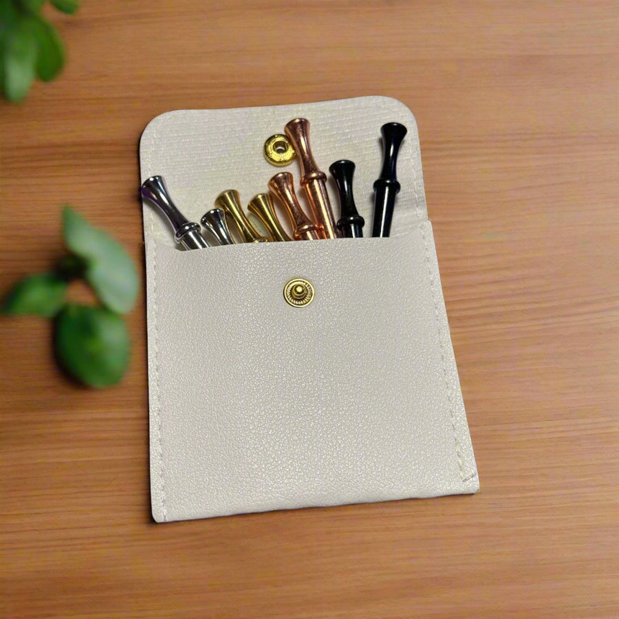 Small beige leather case with metal crib pegs  on a wooden surface