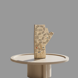 Decorative hand-shaped wooden board with intricate patterns on a dark surface.