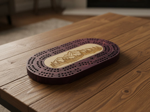 Wooden cribbage board with mountain design on a light gray surface