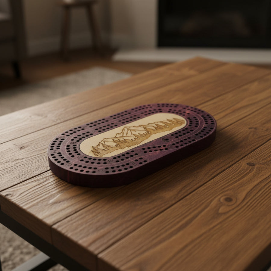 Wooden cribbage board with mountain design on a light gray surface