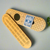 Wooden cribbage board with playing cards on a gray background