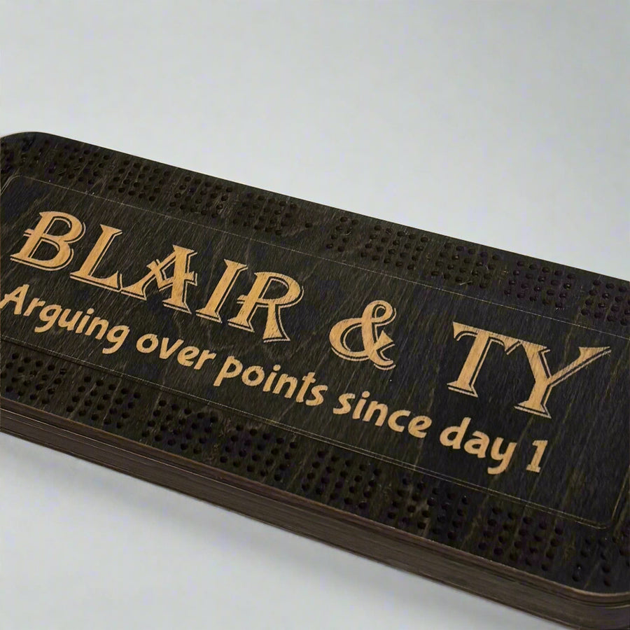 Black cribbage Board with text on a white 