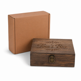 Wooden box with 'Tina's Box' engraving next to a cardboard box on a white background