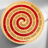 Wooden cribbage board with concentric circles on a gray background