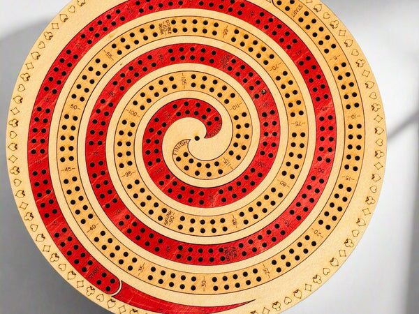 Wooden cribbage board with concentric circles on a gray background