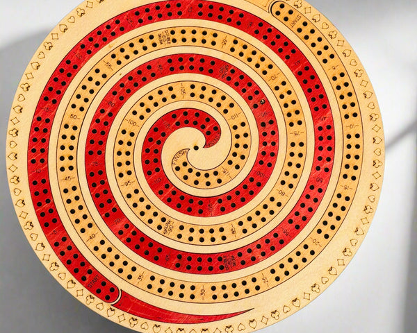 Wooden cribbage board with concentric circles on a gray background