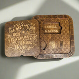 wooden cribbage boards with card holder with engraved text on a gray background