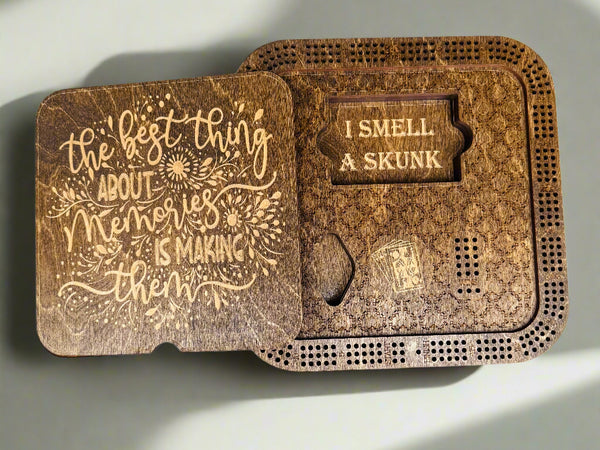 wooden cribbage boards with card holder with engraved text on a gray background