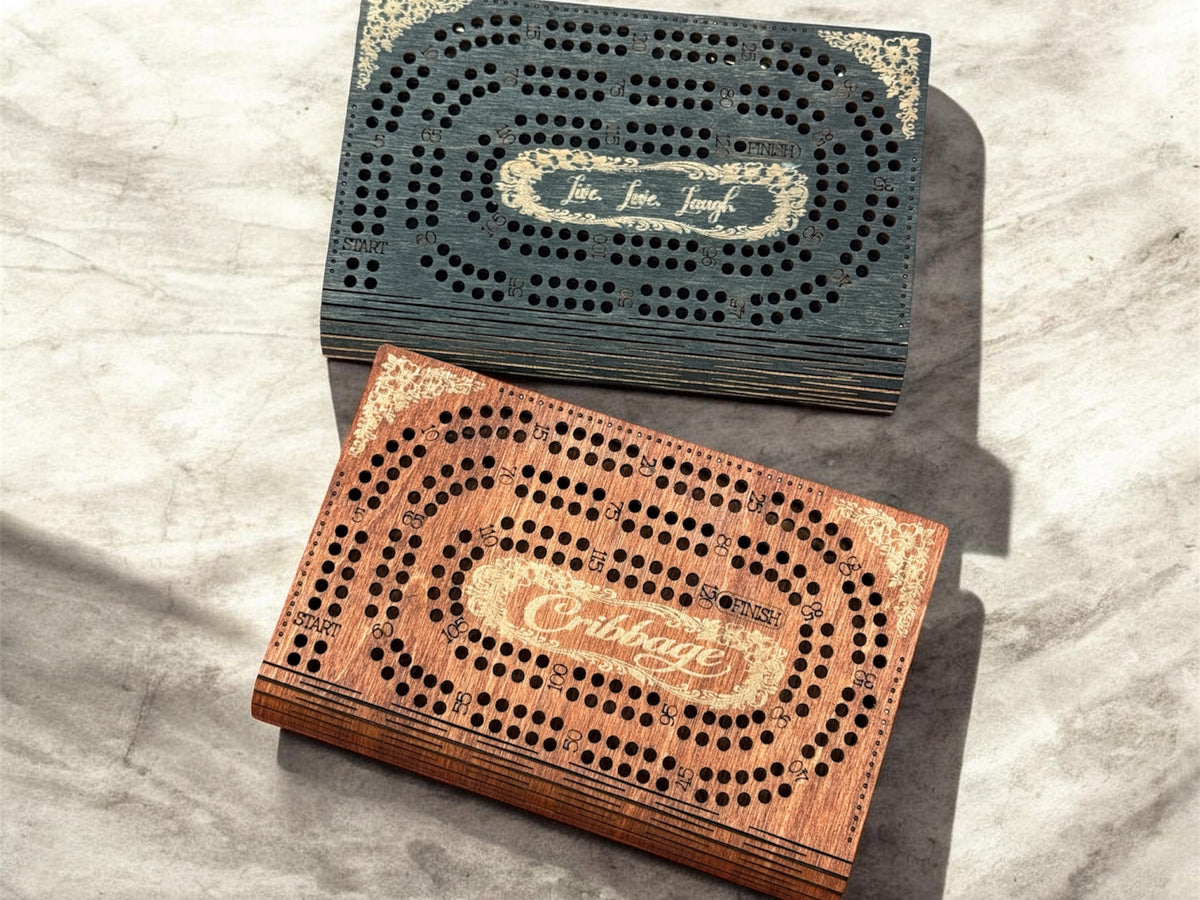 Two wooden cribbage boards stacked on a marble surface